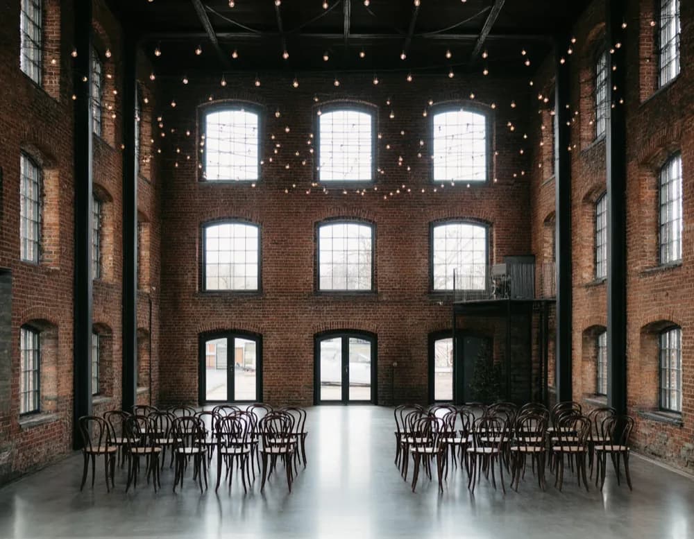 Halle 7 at Haus Plagwitz, bentwood chairs set for a ceremony under six-metre steel windows